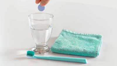Picture of a mouth cleaning set with all essential elements for a good mouth health, including a toothbrush, a towel and a cup of water.
