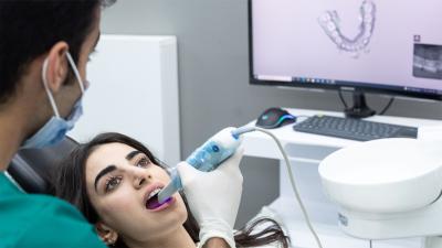 brunette women getting her teeth scanned by a doctor 