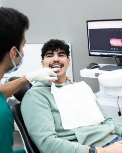 Dentist in his office examinating patient's teeth to explain his clear aligner therapy