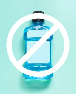 Bottle of mouthwash with a warning sign over it, to warn about mouthwash use and possible risks.